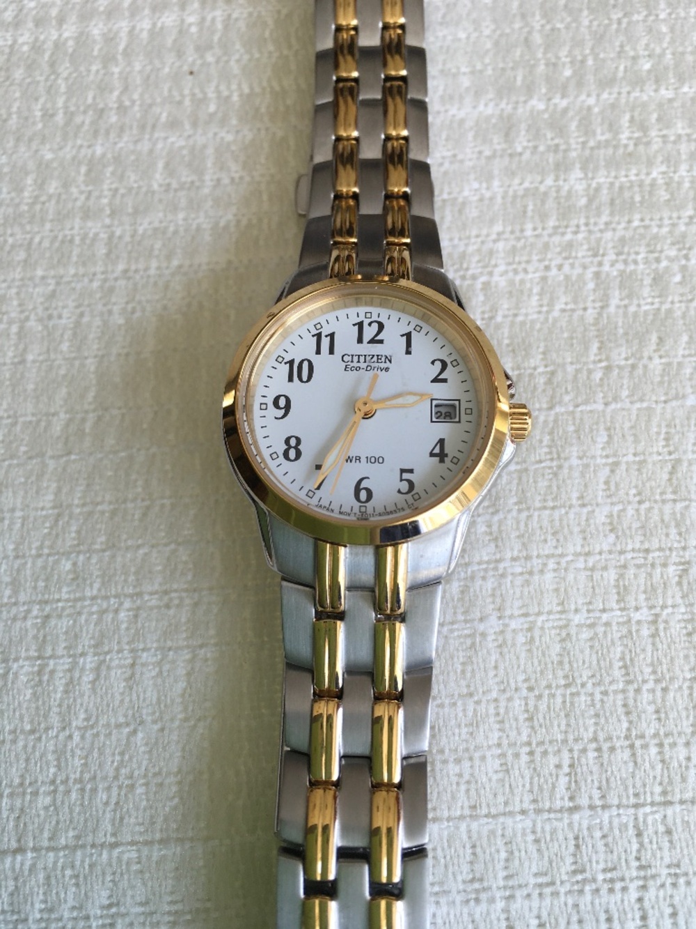 Citizen women’s goldtone and silver wristwatch with white face